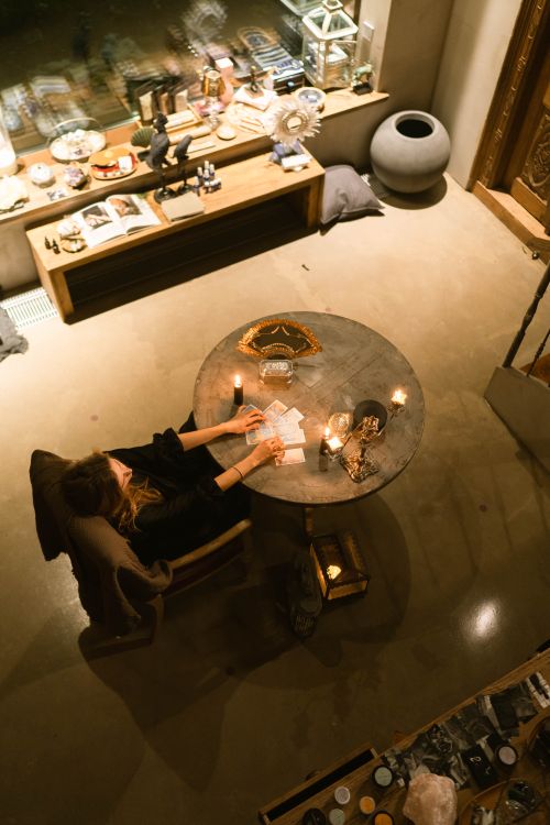 Una mujer realiza una lectura de cartas del tarot en un ambiente íntimo con velas encendidas